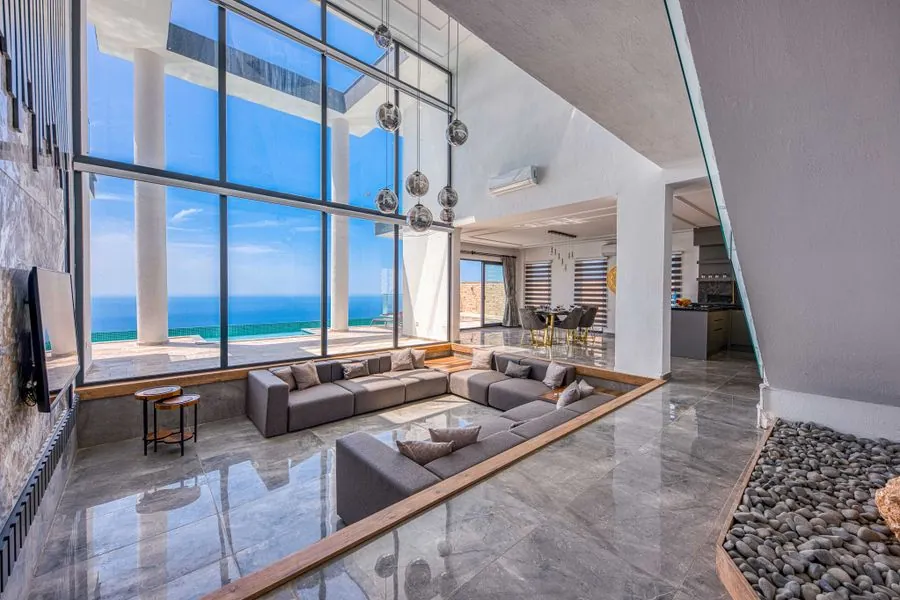 A living room with floor-to-ceiling glass and a sea view
